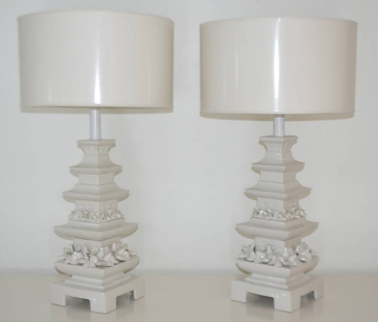 Exquisite pair of Hollywood Regency style Blanc de Chine pagoda form table lamps, circa 1960s -1970s. These stunning lamps are decorated with hand thrown applique and rewired with brass fittings. Height can be adjusted by simply adding a smaller or