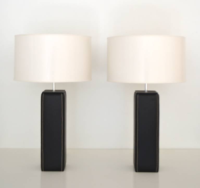 Pair of striking Mid-Century Modern leather wrapped column form table lamps by L. Paul Brayton, circa 1970s. These geometric shaped lamps are double stitched on each corner and wired with chrome fittings. Overall height can be adjusted by simply