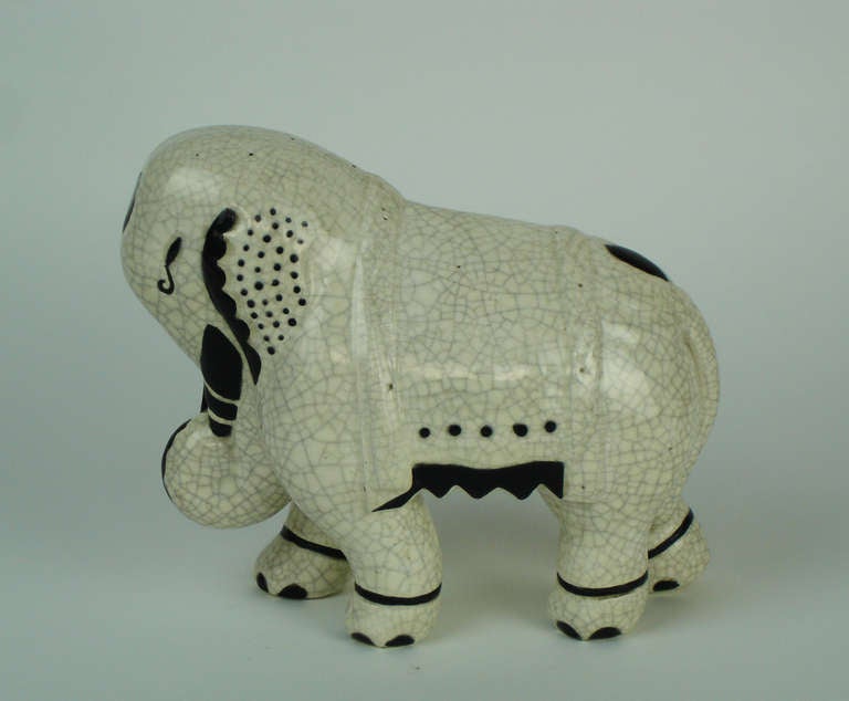 A glazed white crackle earthenware elephant with black decorations.Signed under one foot :Atelier Primavera Longwy France.