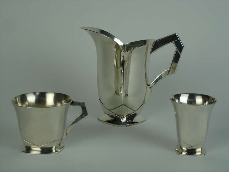 A shaped square with angular handle at corner jug,a small cup ,a cup with angular handle