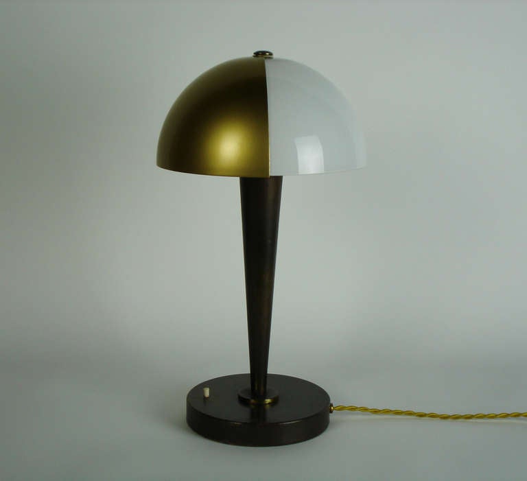 a table lamp with a rotary gilt brass part on a white opal glass shade.A caramel patina steel base