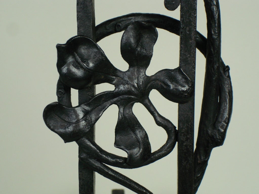 wrought iron andirons, originally painted in black with climbing flowers decorations