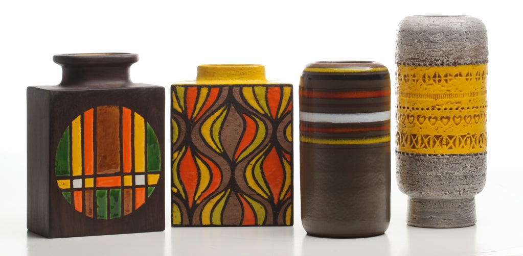 Collection of mid-century Italian ceramics with bright citrus glazes. Patterns in yellow, orange, and lime pop against earth tones. Cylinder vase with incised yellow band is Bitossi for Raymor; the other three are Rosenthal Netter. Tallest is