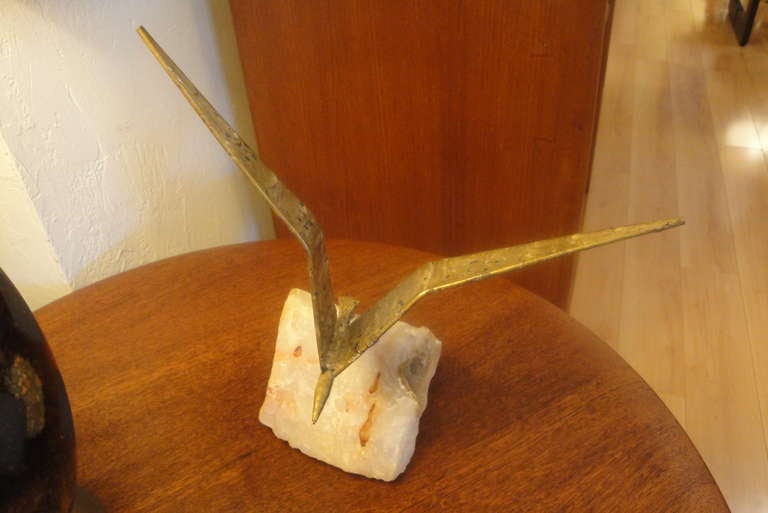 A Curtis Jere metal table sculpture mounted on a quartz base. Bird in flight. Signed and dated 1971.