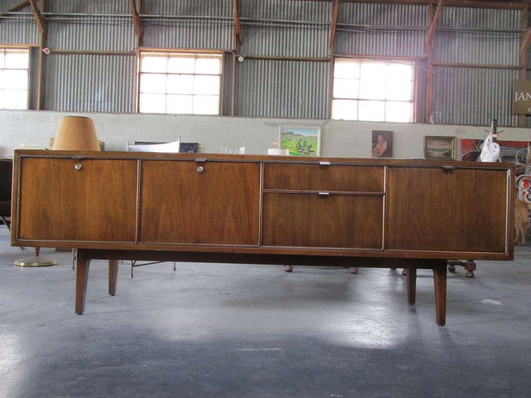 Finely crafted walnut credenza featuring solid oak secondary woods and a fitted 5 section interior with 2 file drawers.  Key to locking components included.