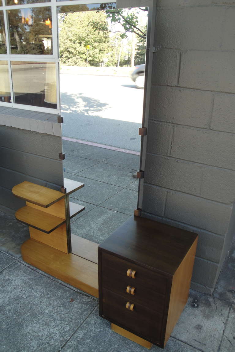 A limited edition vanity designed by Gilbert Rohde for Cavalier Furniture. Retaining its original finish with a unique two-tone walnut veneer. Bamboo like banded pulls, ribbon cut mahogany interior and dovetail construction. A fine and scarce