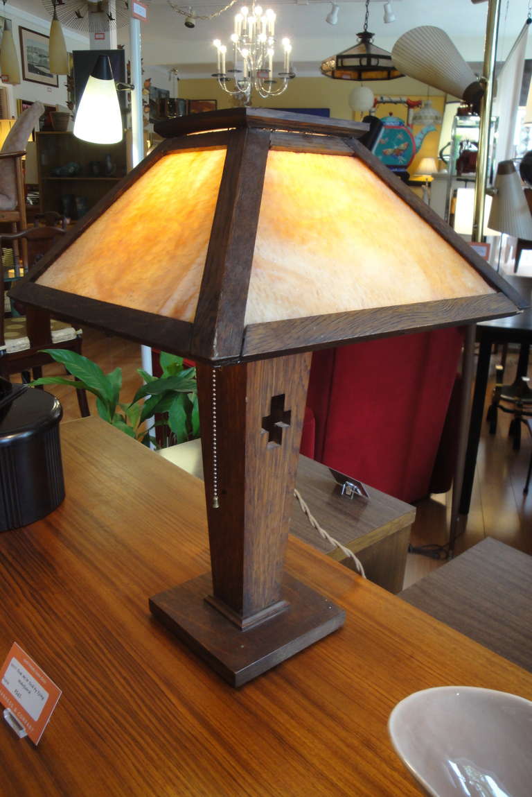 Unusual example of an American Arts & Crafts table lamp with original caramel opaque glass and a pierce-cut design element.