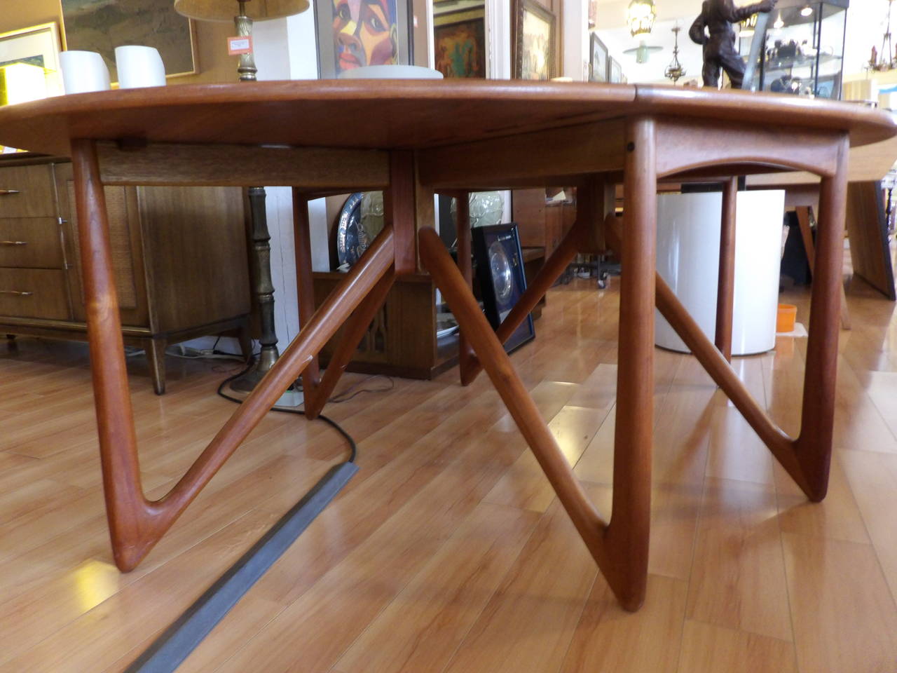 A striking and finely crafted Danish modern teak drop-leaf dining table attributed to Kurt Ostervig and/or Neils Kofoed, Denmark, circa 1960s. Retains branded Danish Import control and stamped 