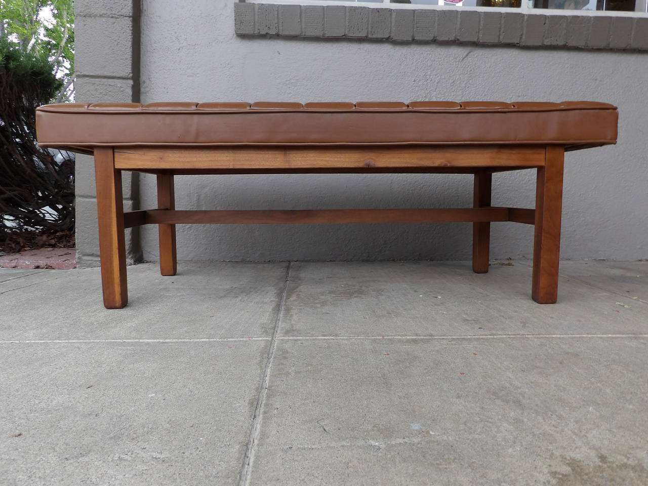 A Classic 1960s American modern button tufted bench in vinyl with a solid walnut frame.