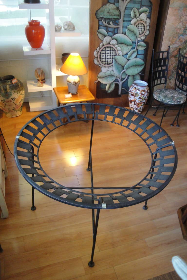 An indoor / outdoor circular iron, glass top, dining table by John Salterini.