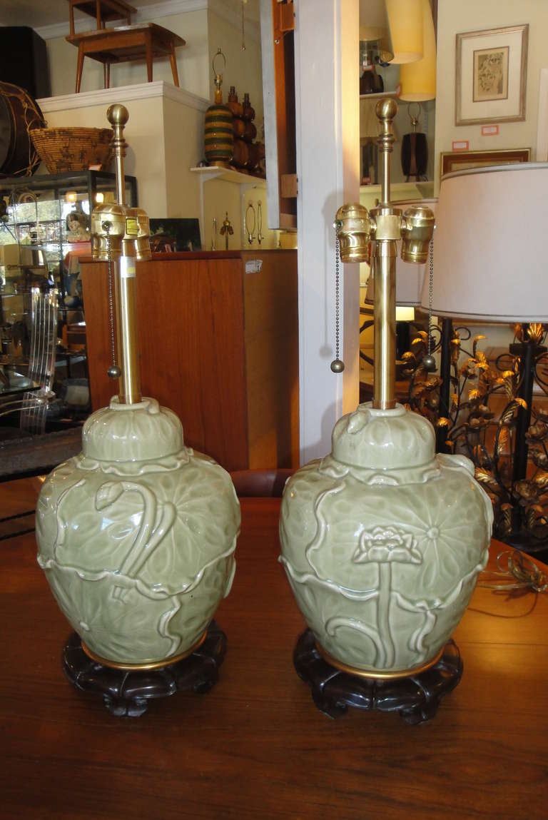 Beautiful pair of green celadon lamps with carved rosewood bases by the Marbro Lamp Company. Retaining original finials and Marbro labels. Sold without shades. Measurements are to top of lamp finial.