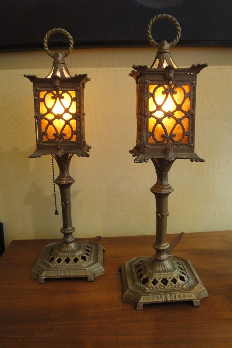 A pair of cast iron and mica Spanish Revival lamps by J.J. Braze, New York. Original painted finish and original mica shades.
