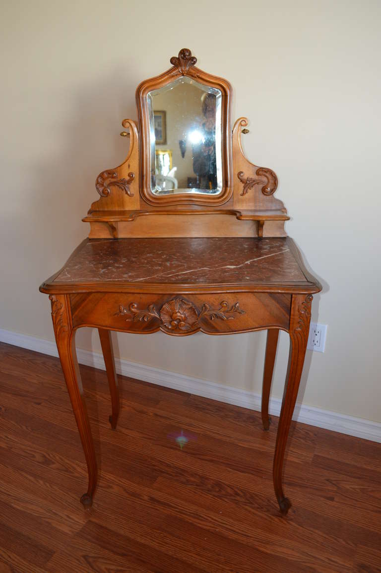Louis XV style vanity with hand carved details and swivel mirror.
It has one drawer and the original marble top.
Inside the drawer, see photo, there is a hand written note from the 
giver, dated 1st of January, 1924.