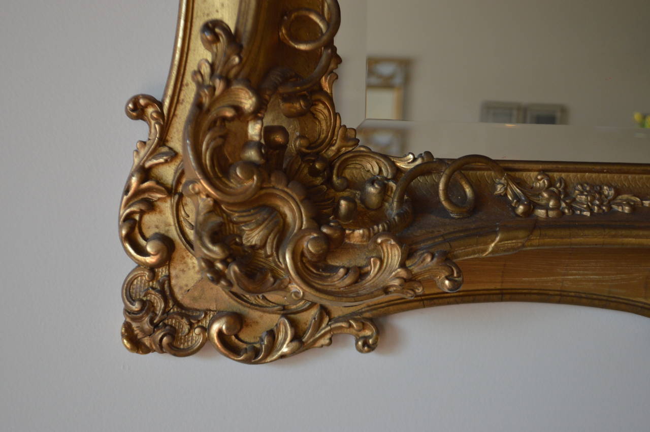 Amazing carved details on this mid-19th century gilded frame. The beveled mirror is new.