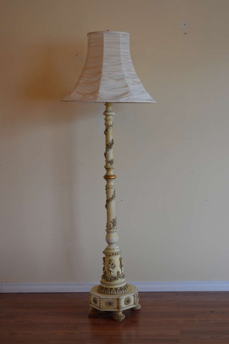 Unusual floor lamp, hand carving base showing putti playing musical instruments.
Further hand carving of acanthus leaves and flowers around pole of the lamp.
The lamp shade has been custom made allowing the light to go through the fold of the