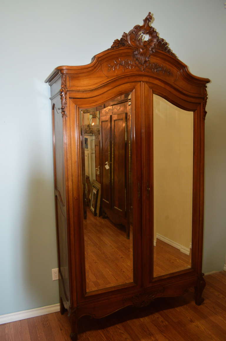 Beautiful and extensive hand carved details on the Louis XV style solid walnut
armoire. The mirrors of the two doors are beveled. There is much storage, five shelves and two locking drawers at the bottom. The walnut patina is lovely and warm.