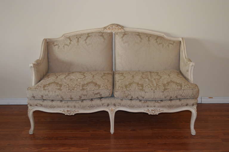 Pair of Louis XV style painted canape, gilded accent has been added to the hand carved details on the top as well as on the apron of the canapes.
The fabric is not new but in good condition, damask pattern, tone on tone in soft oyster tone. The