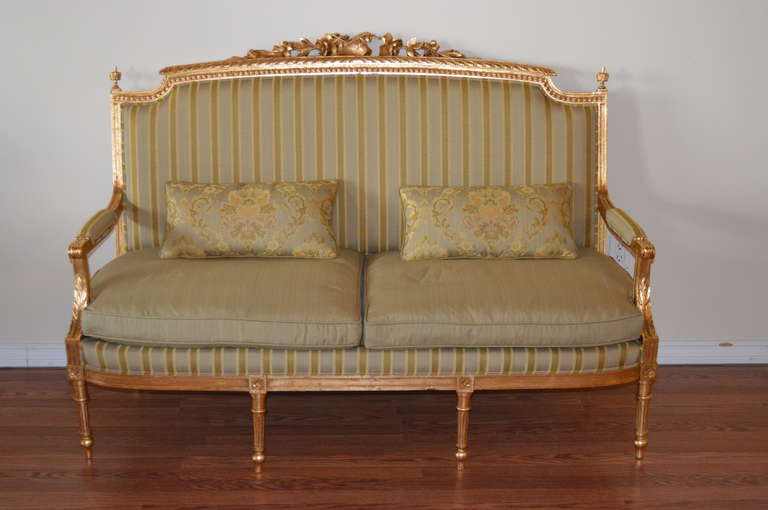 Extensive hand carving on the frame of this 19th Century canape.
It has been gilded and newly upholstered with complementary fabric.