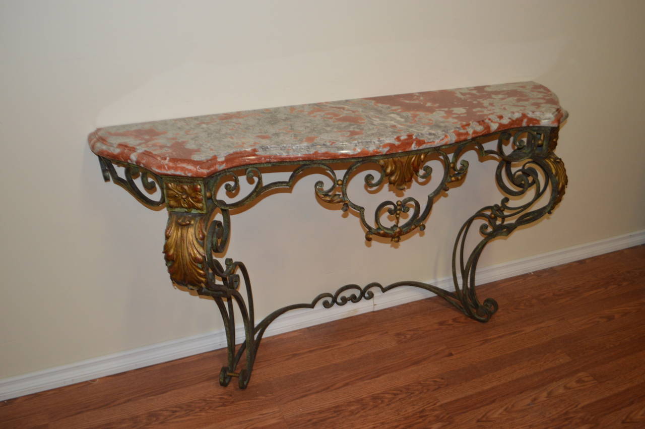 Louis XV style,elegant wrought iron console table with decorative elements finished in bronze tone. The rouge royal marble is beautiful and original.