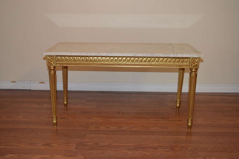 Louis XVI style gilded over wood coffee table with carara marble top.
There are nice carved details and Louis XVI style crest on the apron of the coffee.