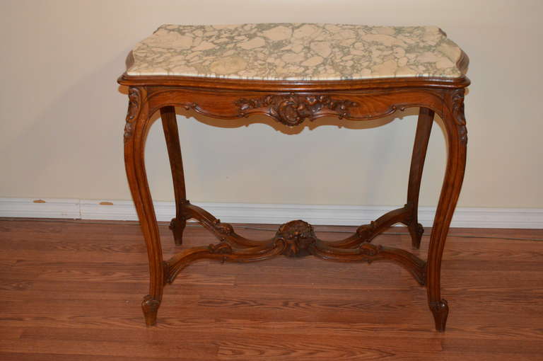 Louis XV style walnut console or table the salon. It has extensive hand carved details and the marble top is original