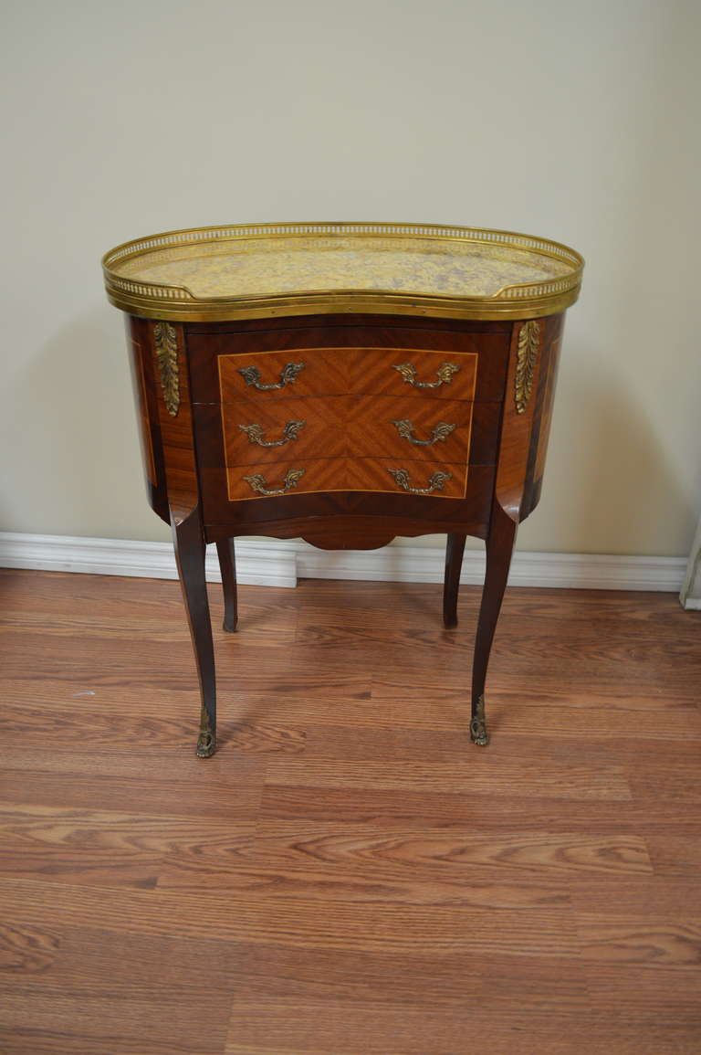 Lovely pair of Transitional period kidney shape side table with marble top.
There are three drawers and the tables are finish all around in a nice inlaid pattern. There is a bronze gallery and bronze hardware.