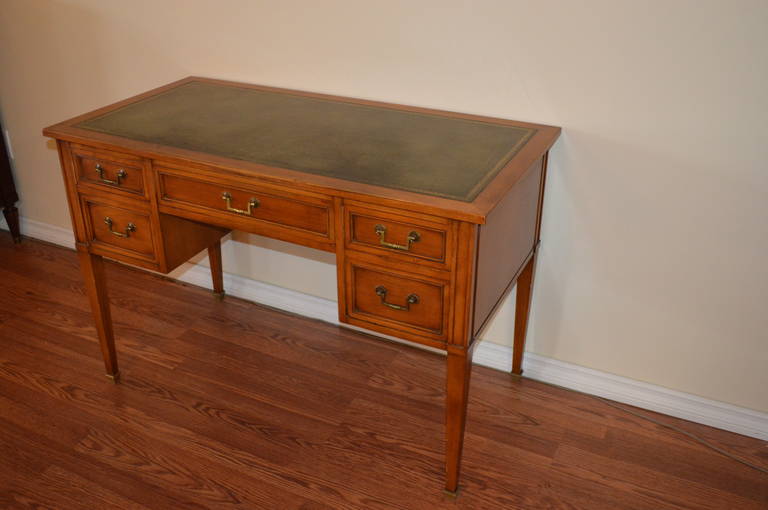 A fine quality Louis XVI style solid fruit wood desk with good storage. The hardware is bronze and original. The green leather top has gold tooling and is in good condition.