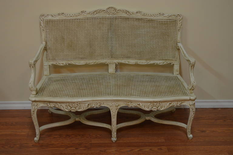 A beautifully hand-carved and painted, canned settee from Provence.
The cushion has been added using a printed cotton showing a French beach scene of the late 19th century.