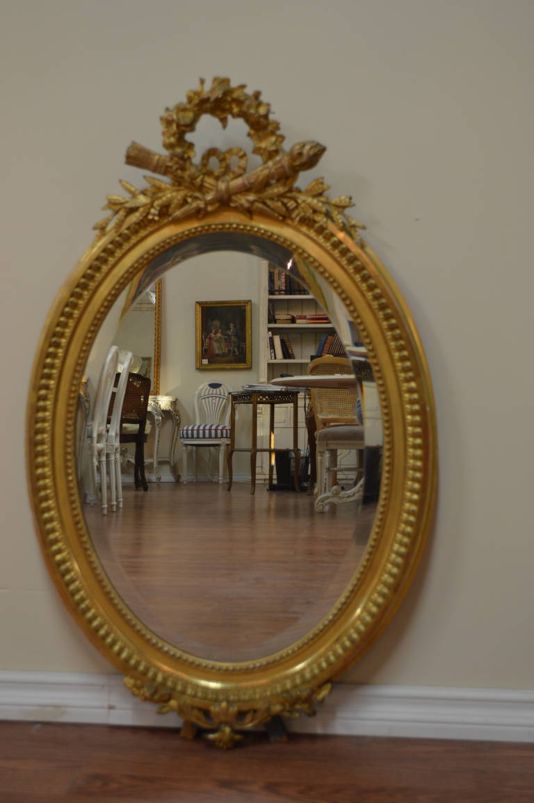 A fine quality Louis XVI style gilded frame and beveled mirror.