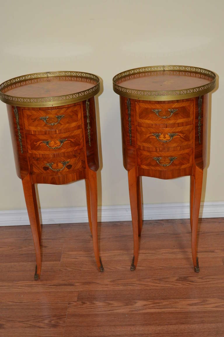 Charming side tableswith inlay work all around the tables. They have three drawers and some nice bronze details on the sides and at the feet.