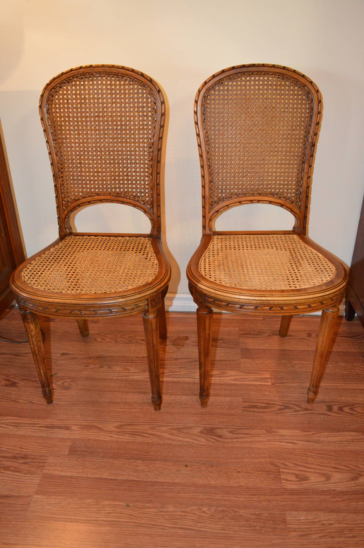 Set of 8 Louis XVI style caned back and seat oak dining chairs.
They have the Louis XVI style rope carved details all around the back and seat of the chairs.