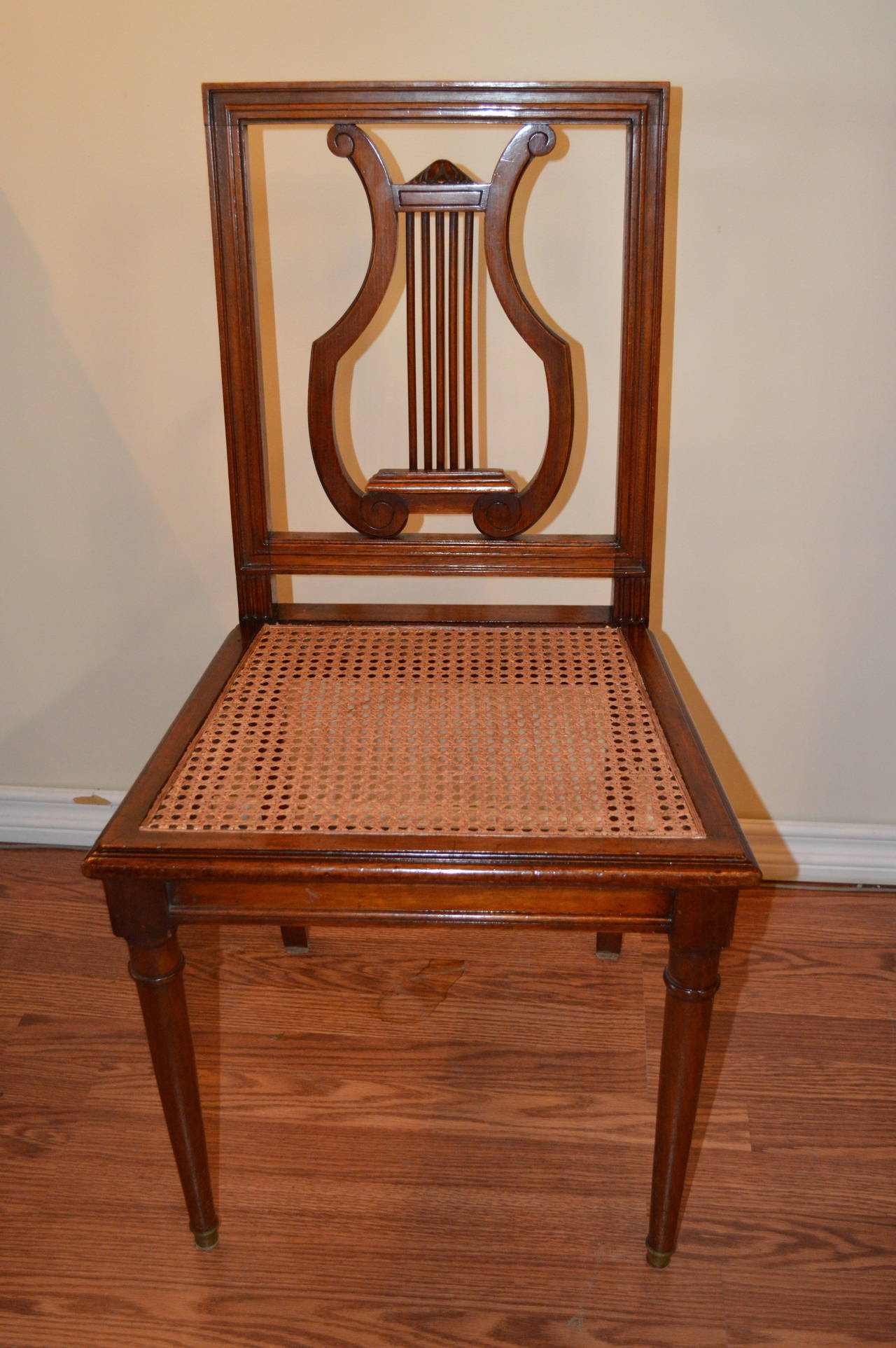 Set of six mahogany harp back dining chairs with caned seat.