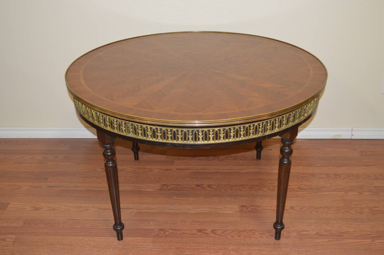 Louis XVI style mahogany round table with an amazing inlay herringbone pattern
inlay top as well as a bronze frieze all around the apron of the table.