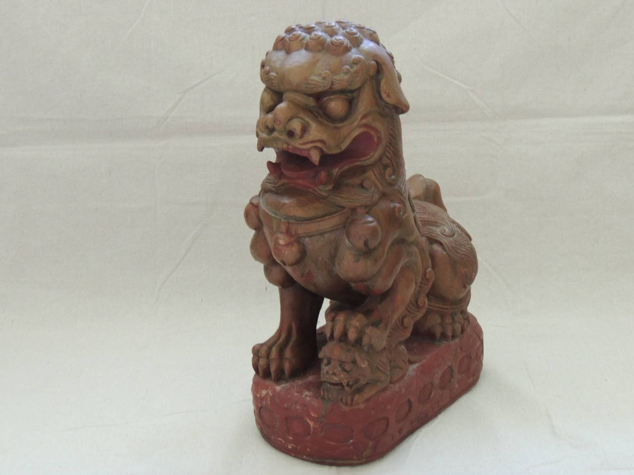Wood carved foo dog holding cub, solid wood carving, reddish paint and traces of gold leaf all around (heavy).