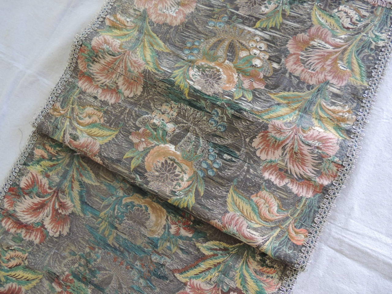 18th century French brocade (heavy) embroidery table runner or sofa back textile. Table runner motif depicts orange flowers, green leaves and silver metallic threads background. Framed with a silver trim and green linen backing.  Ideal for the