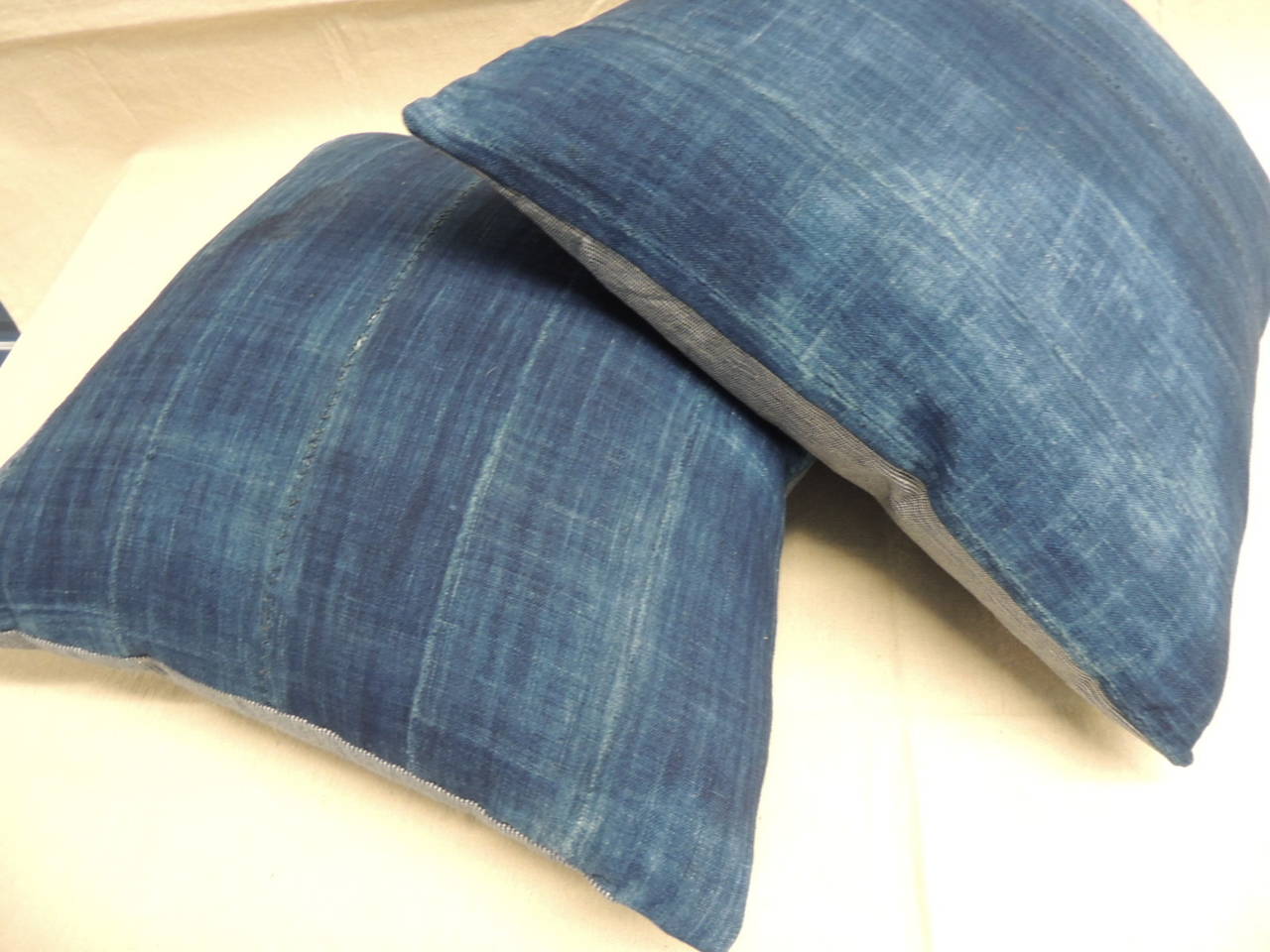 Pair of African indigo mud-cloth pillows with strie linen backing. (the mud-cloth are individually sewn strips of textile.)