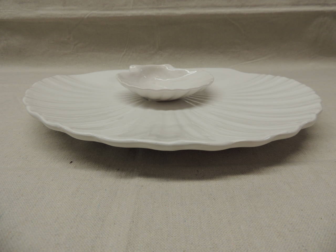 White ceramic sea shell serving dish with small sea shell dish on top.