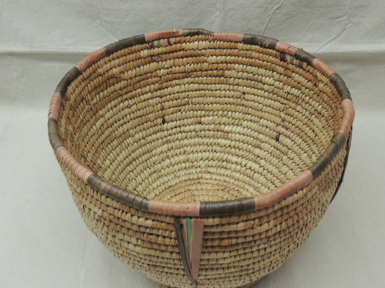 Round vintage open top woven Olla basket/Planter with footed edges and thin colorful details around top and on the side.
Ideal for a table, cabinet, sideboard.