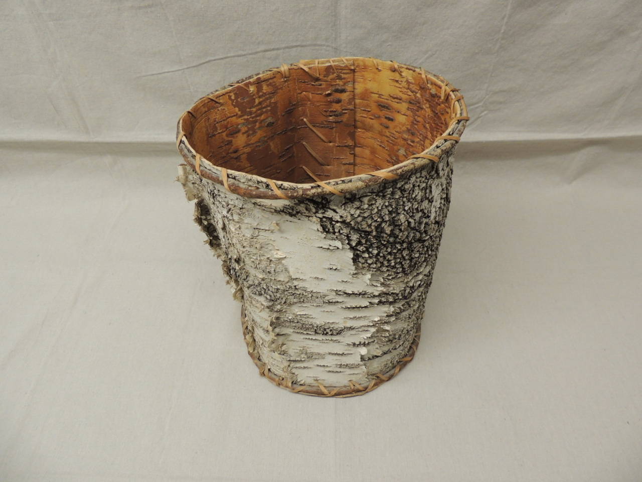Tree bark waste basket, hand crafted of tree bark and weave with vines and thin rattan edges. The bottom of the basket is cover in bark.