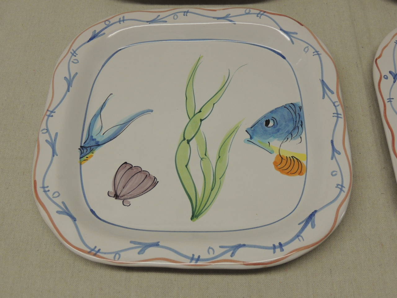 Set of four ceramic hand painted square plates, depicting 