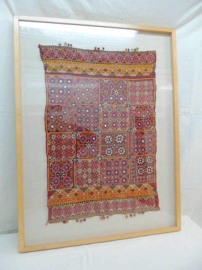 Vintage framed "Shishar" embroidered Indian textile with small mirrors details.
Cotton and silk mirrorwork, with tassels.
Mounted on natural linen backing, maple frame, UV plexi.
Actual textile size: 18" x 27" H.