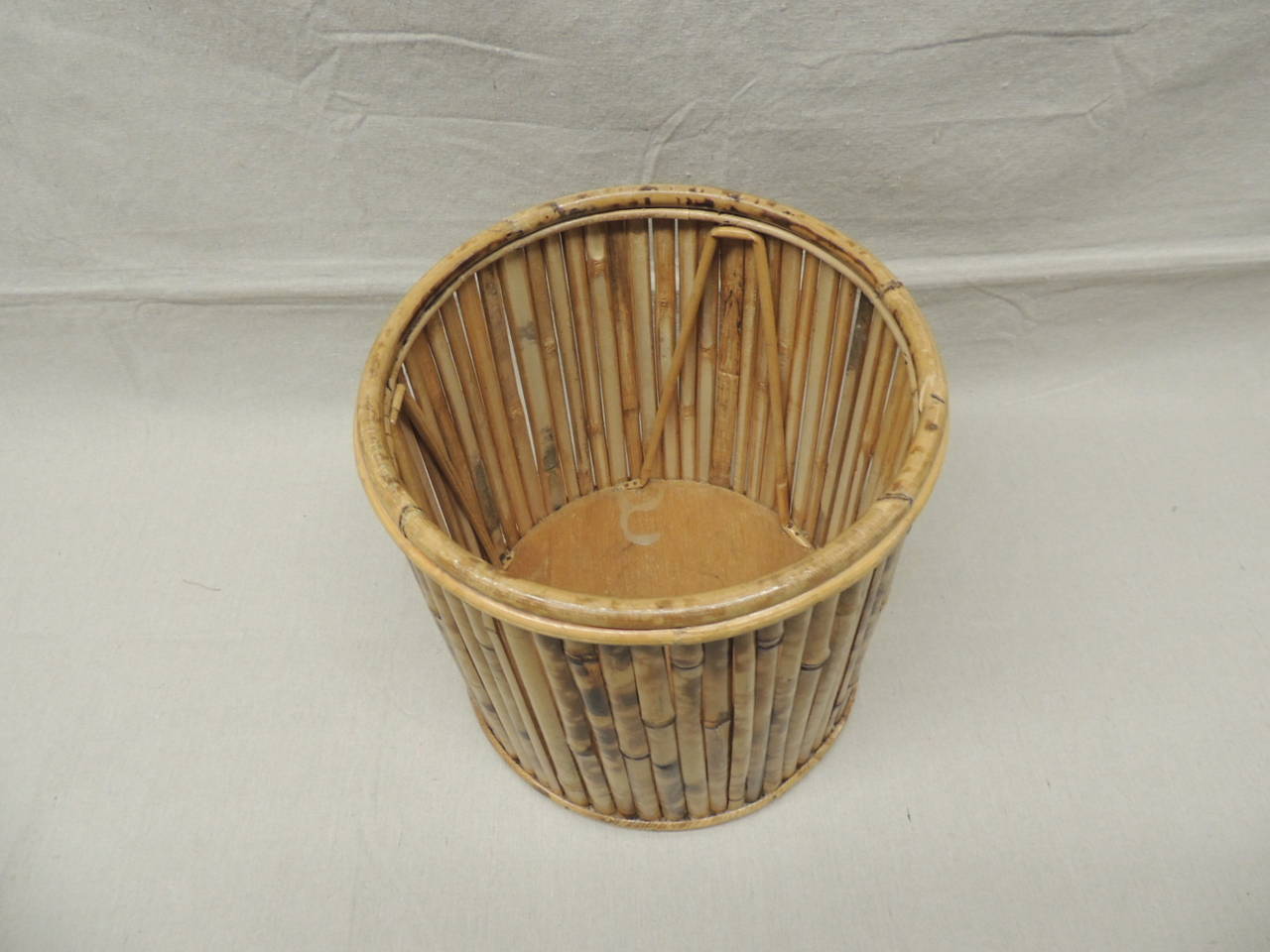 Vintage round bamboo waste basket/planter with a turtle shell faux pattern.with ridded details on top and bottom, wood base.