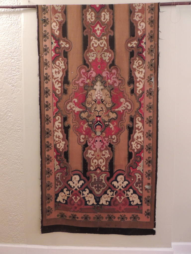 Large antique Aubusson tapestry, wall-hanging or portier. Center medallion with scrolling design border. In shades of red, black, tan. Black border. (Needs some seams to be re-attached)