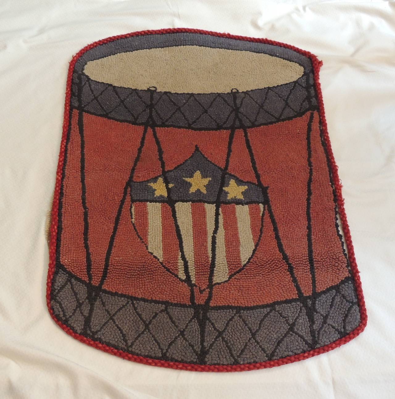 This item is part of our 7Th Anniversary SALE:
Vintage drum hook rug. With USA flag details. In shades of red, natural, grey, blue and yellow.
Rug hooking is both an art and a craft where rugs are made by pulling loops of yarn or fabric through a
