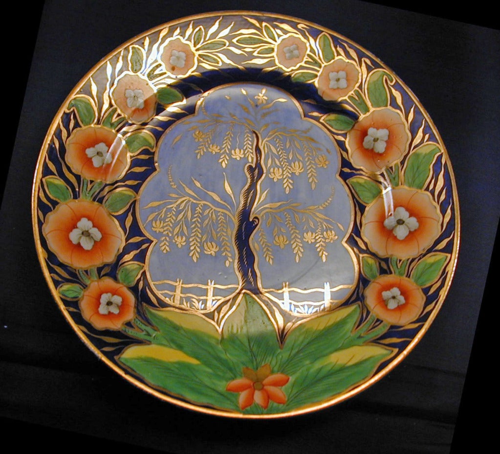 The tree of life, emblazoned with golden leaves, rises from the green earth, against the bluest sky. A gilded fence protects it from a field of wheat and a halo of orange flowers crowns its glory. One of the most beautiful of Coalport's Imari