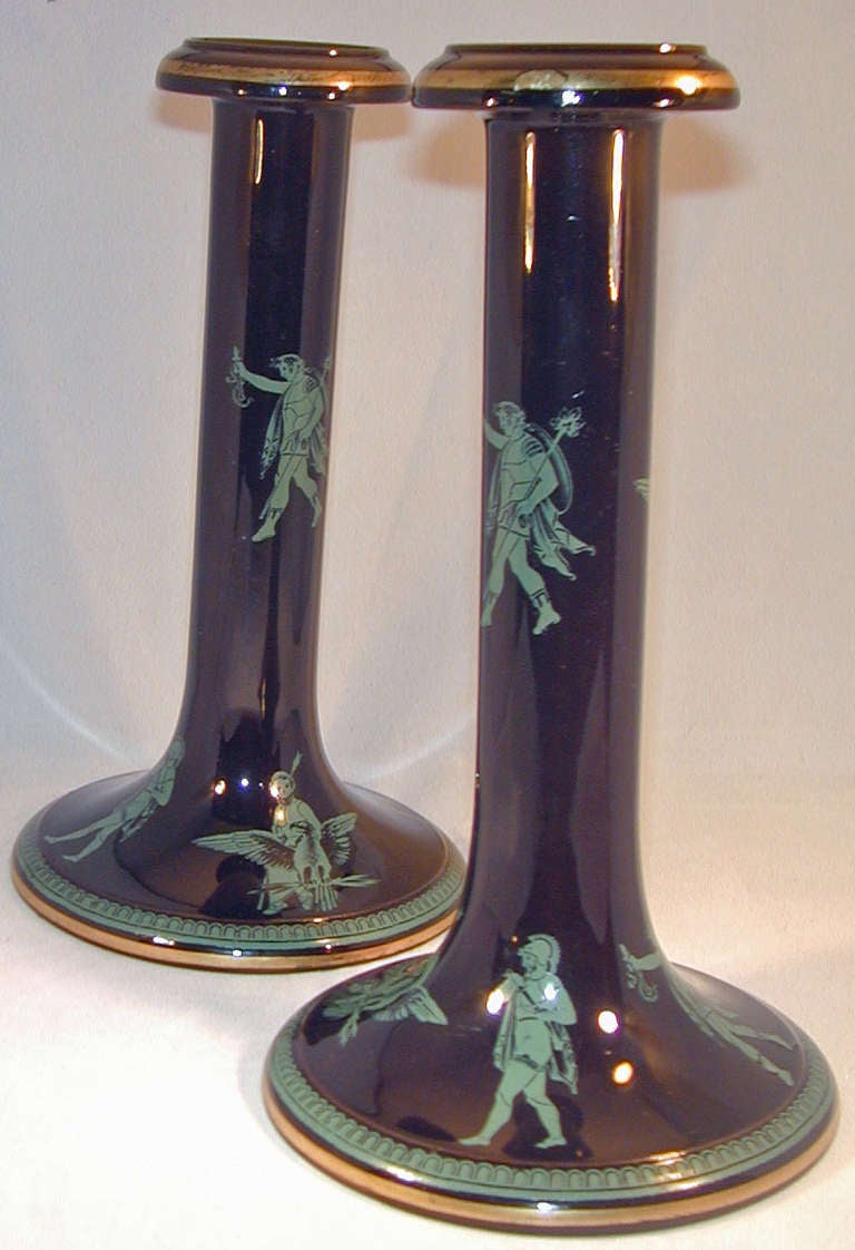 Classical pair of Jackfield Ware candlesticks with turquoise colored Roman figures on a black background. This pottery was first made at Jackfield, Shropshire, England, in the 18th century with a red clay body often decorated in relief and