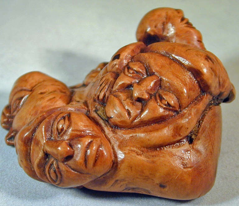 Unique Georgian snuff box depicting five faces and inspired by Japanese netsuke designs. Carved from a tree root, it is fitted with a lidded metal compartment. This unusual piece measures 2 1/2