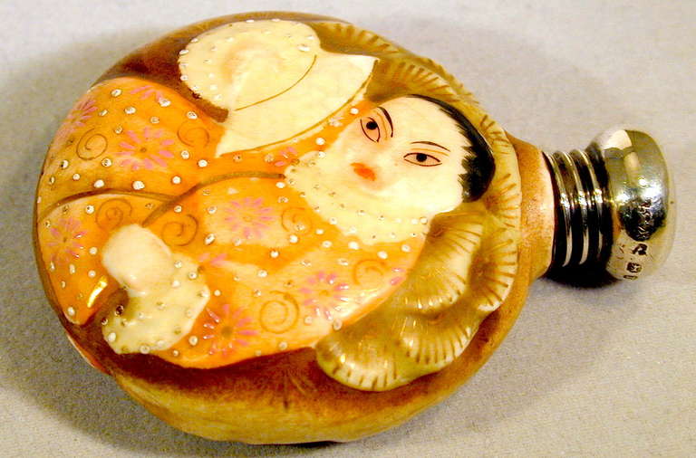 Flacon de parfum en porcelaine Royal Worcester décoré dans le style du Satsuma japonais. Le motif représente une Geisha et un poisson d'un côté et une femme avec un éventail de l'autre. Le CAP en argent porte les poinçons de Birmingham, Angleterre,