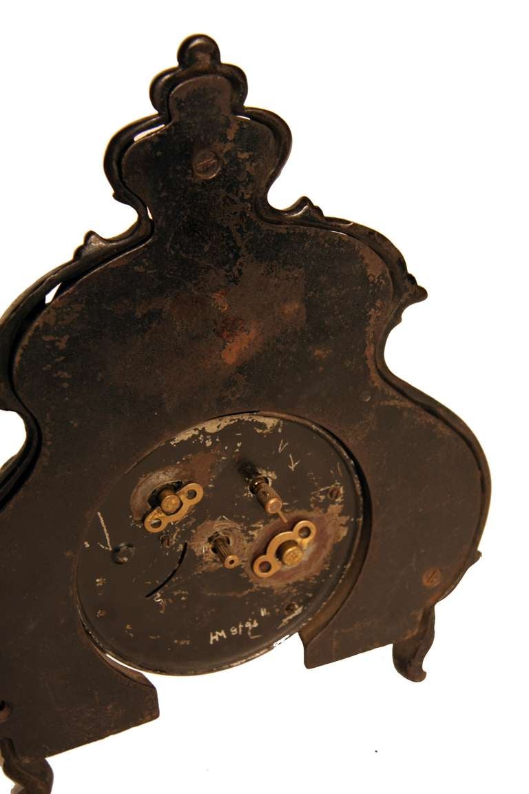 Beautifully detailed cast iron mantle clock. Three footed and painted black, this highly decorative Victorian wind up still works. Great shape, good letter font and great gold colored embellishments on the face.