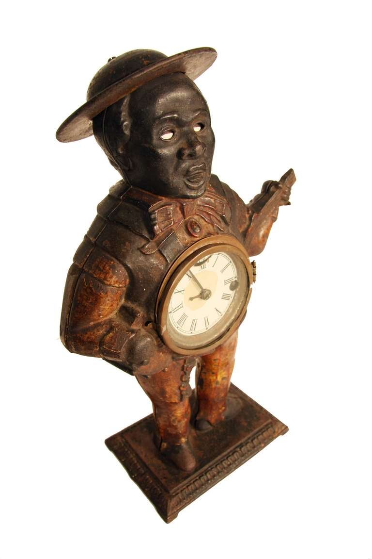Unusual black Americana piece. Original painted vest, shirt and pinstripe pants. All very sturdy, and operational. Clock inset into banjo, and contains original clock face and old glass lens. Clock face is trimmed in brass. Gentleman stands on a